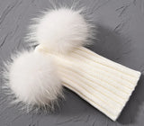 White knit hat with fur pom poms